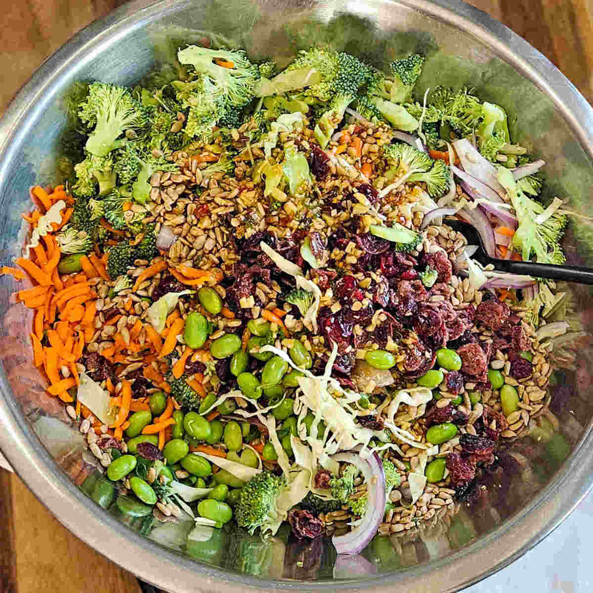 a large mixing bowl with ingredients for the easy Asian broccoli crunch salad.