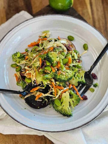 The easy Asian broccoli crunch salad on a plate with a serving spoon and fork.