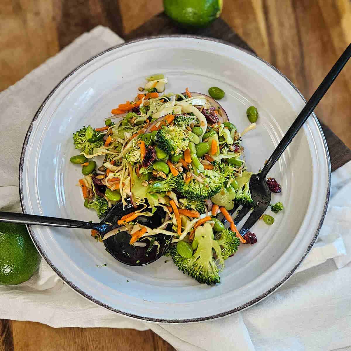  Asian broccoli crunch salad on a plate with a serving spoon and fork.